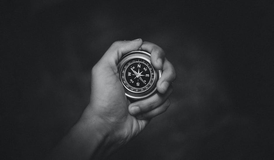 Image description: A person holding a compass with arrows pointing in different directions, representing diversification in investments.