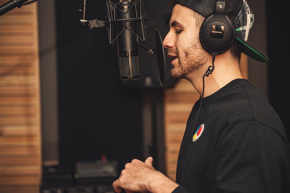 Image of a person recording a podcast with a microphone and headphones.