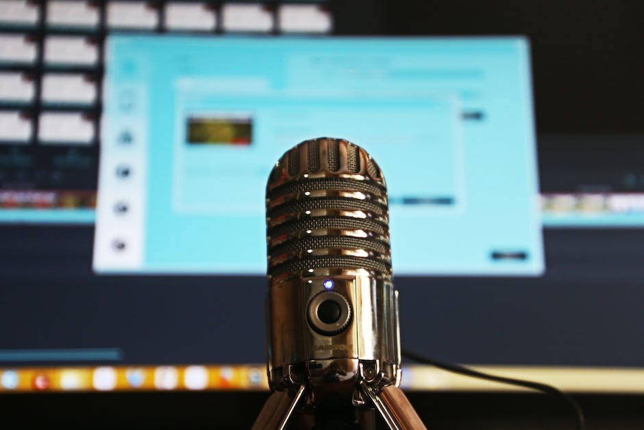 Image of a person speaking into a microphone while recording a podcast.